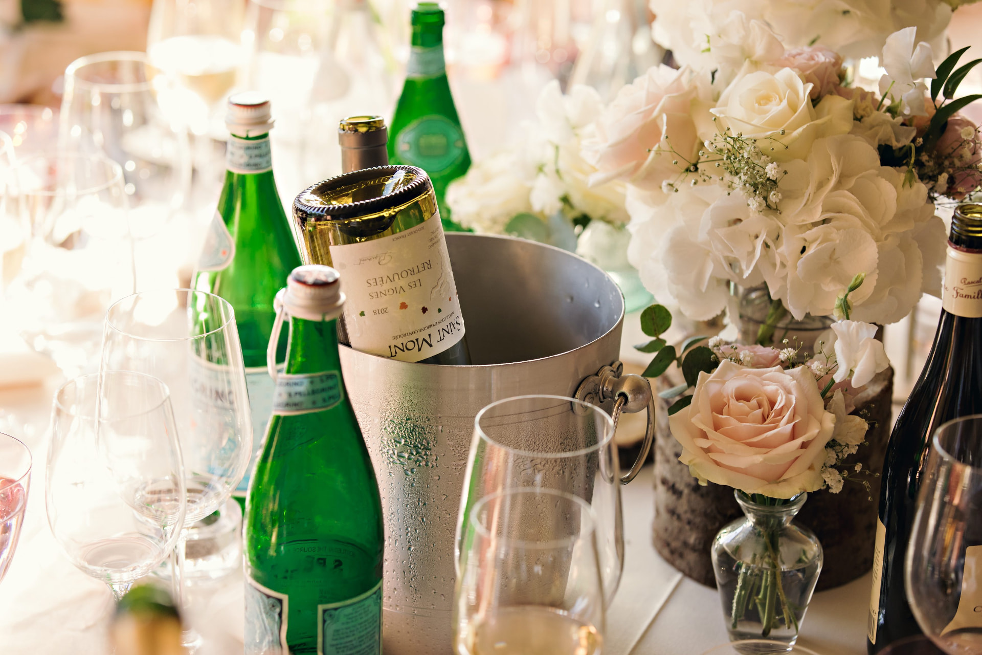 Close-up of a wedding table with wine, glassware and flowers