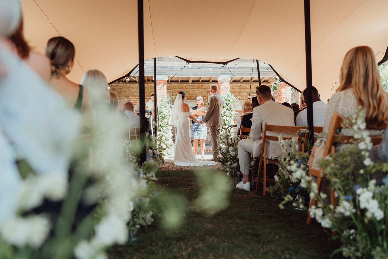 Bride and groom exchanging vows during a garden ceremony at Bignor Park
