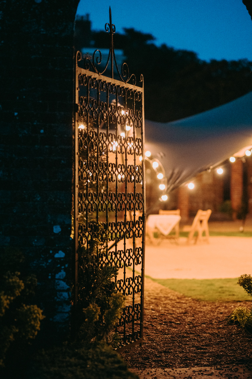 Evening reception lighting through an ornate gate at Bignor Park