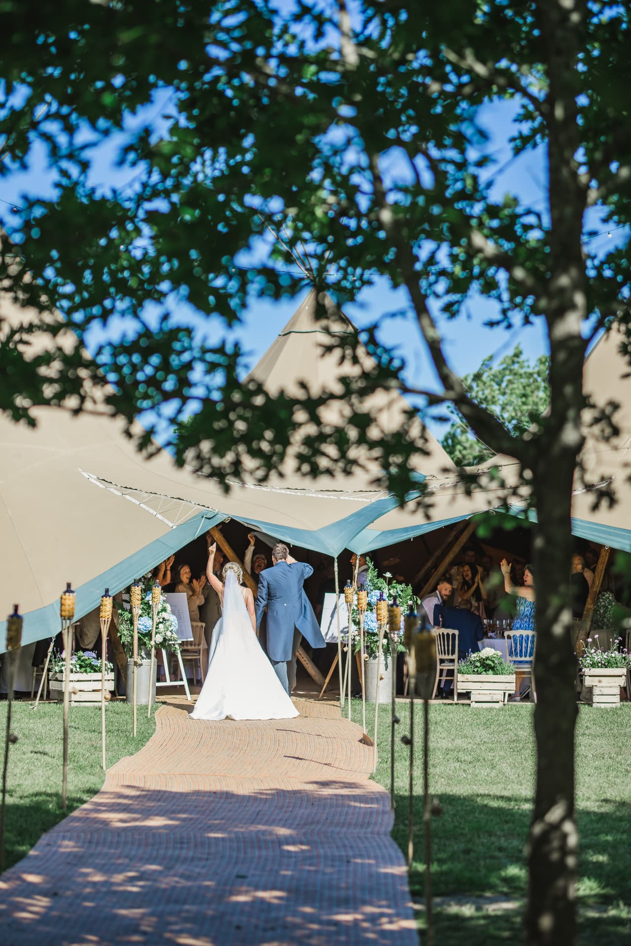 Bride and groom walking down the aisle to a tipi reception at Sumner's Ponds