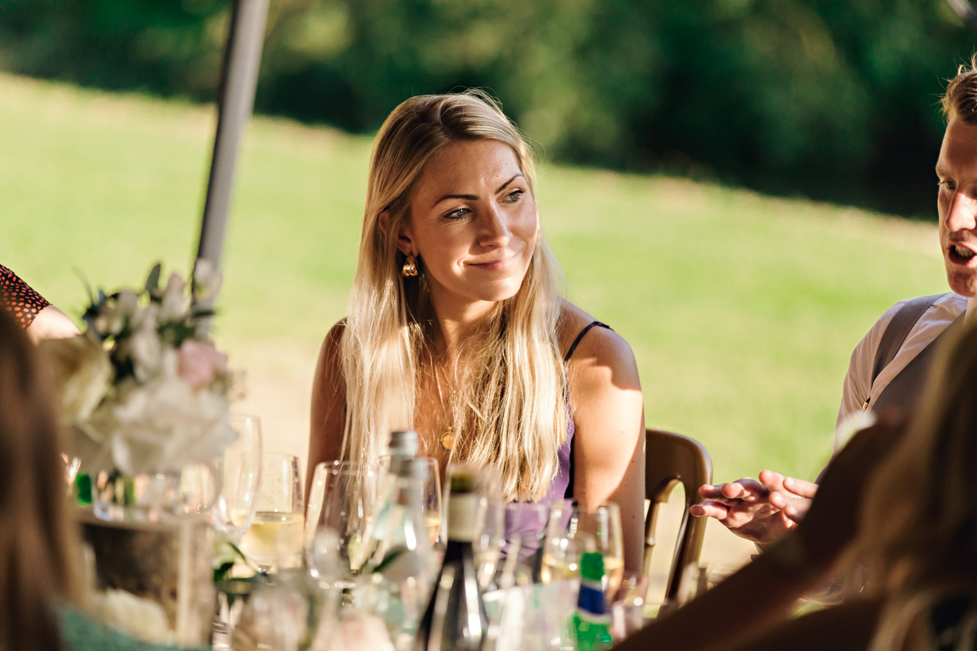 A wedding guest smiling during an outdoor reception