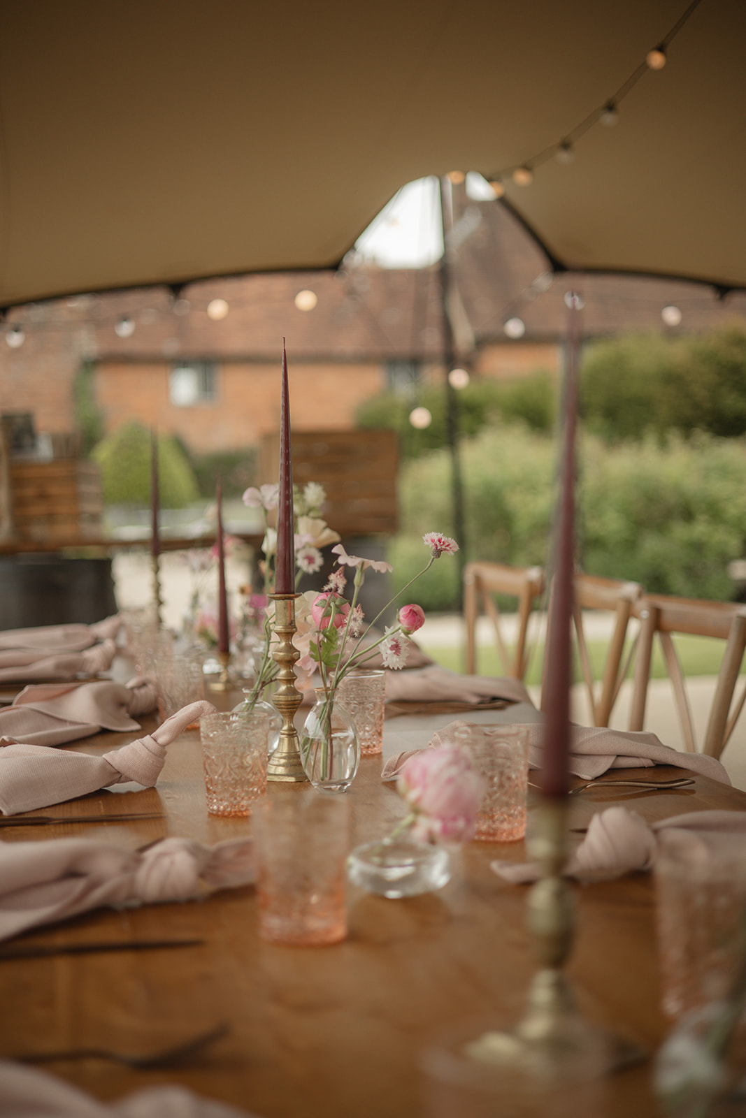 Long wedding table with brass candlesticks and glassware at The Walled Garden, Cowdray