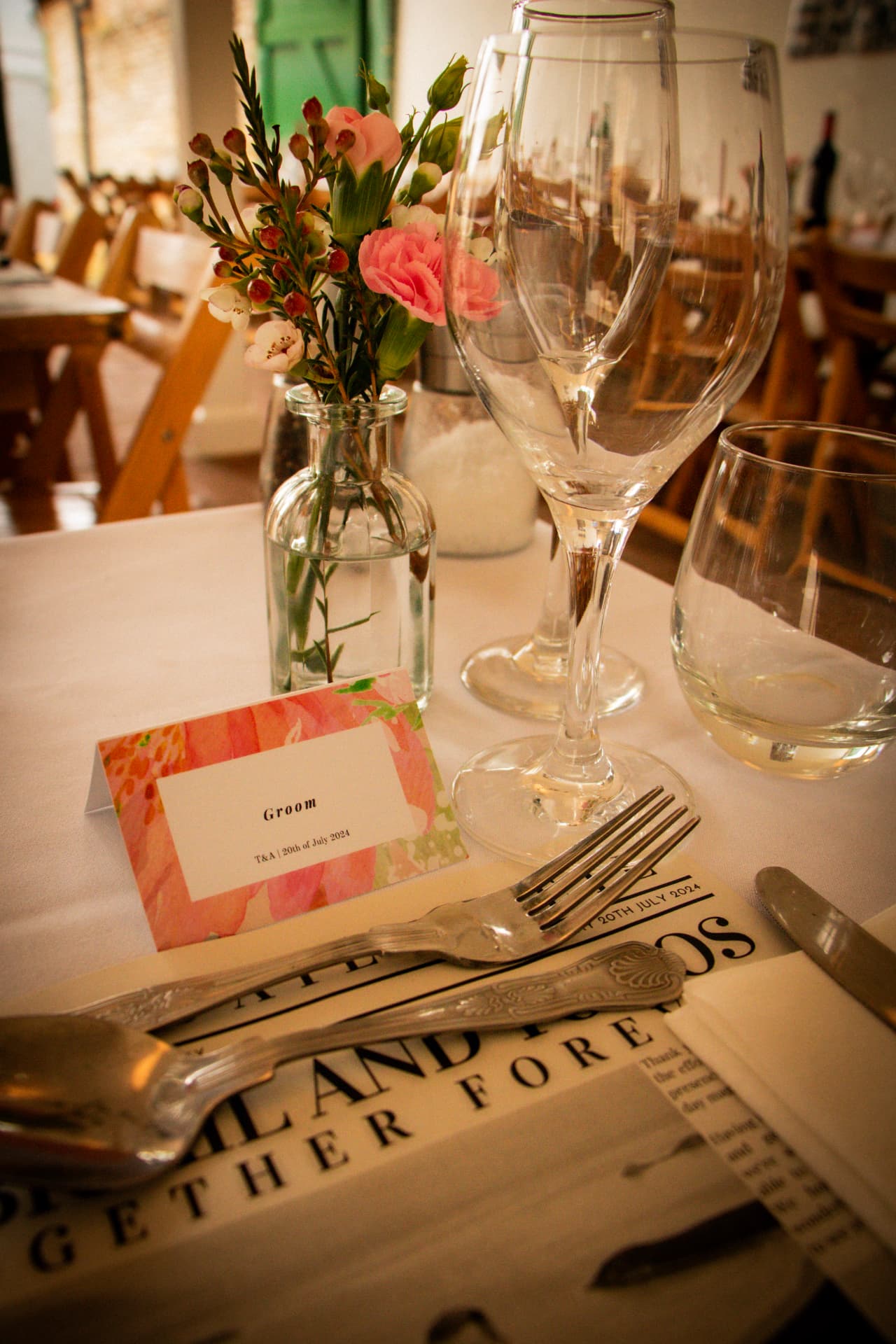 Place setting with flowers and a name card at a Bignor Park wedding