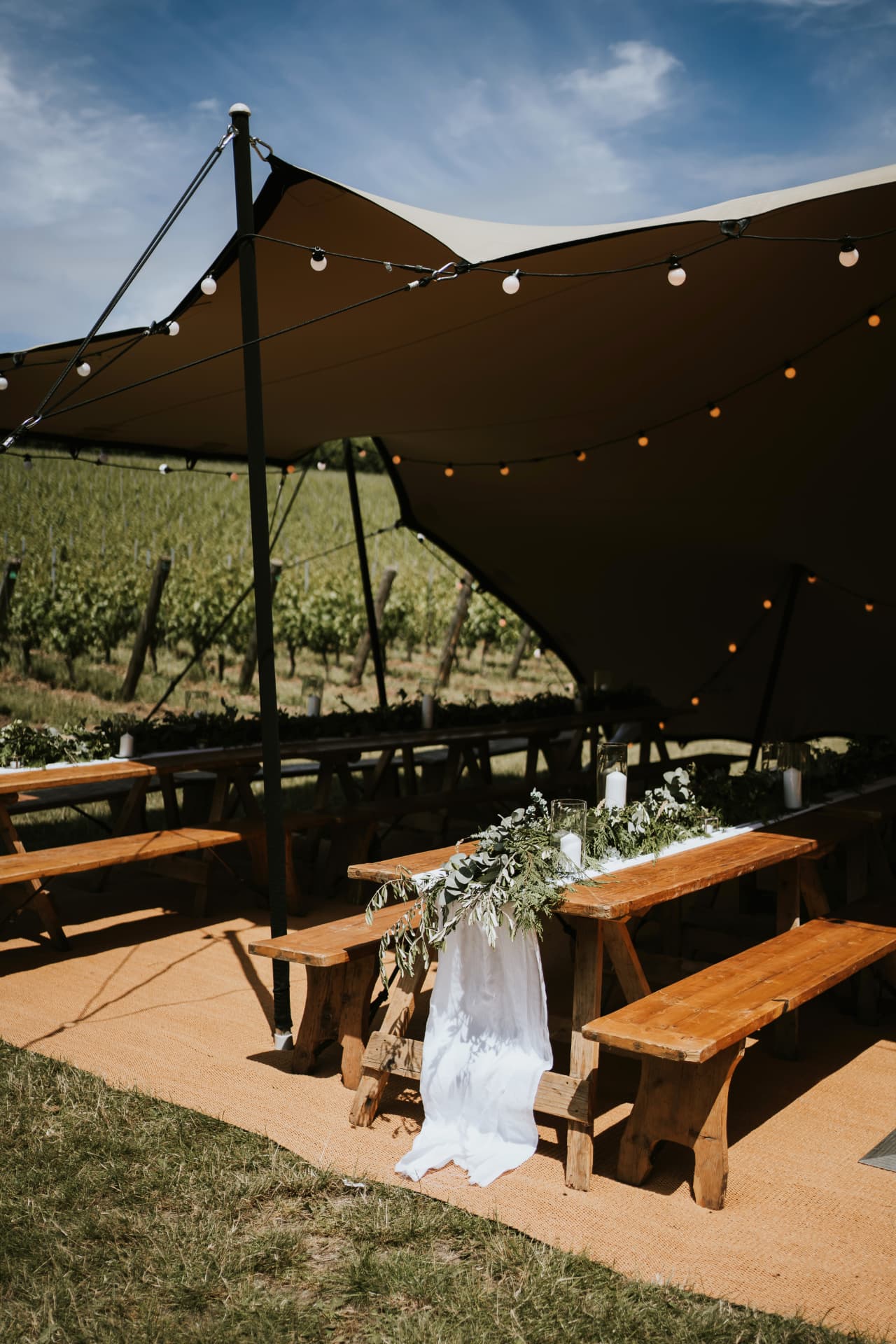 Decorated rustic wedding tables under a stretch tent at Wiston Estate
