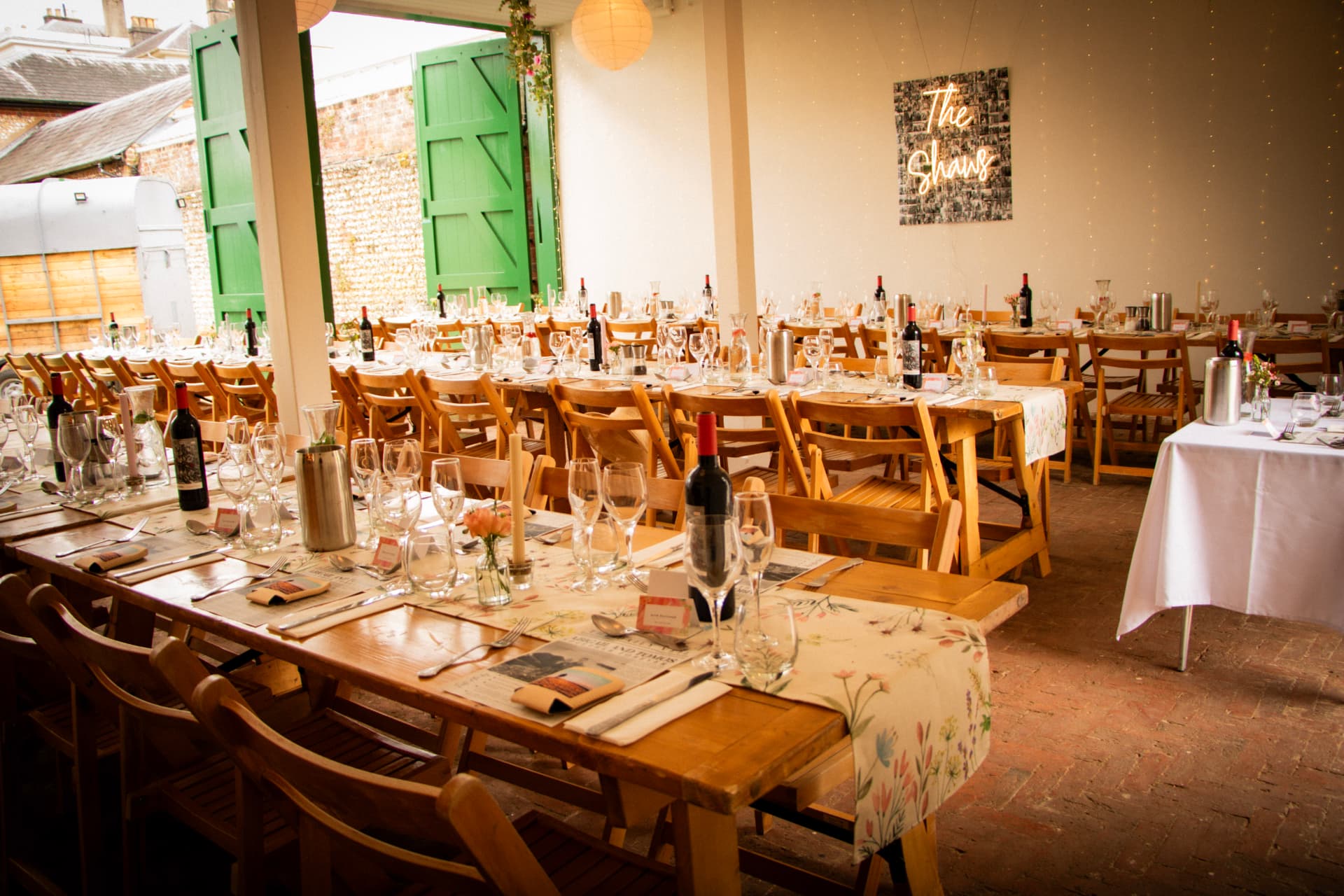 Long rustic tables and wooden chairs set for a wedding meal at Bignor Park